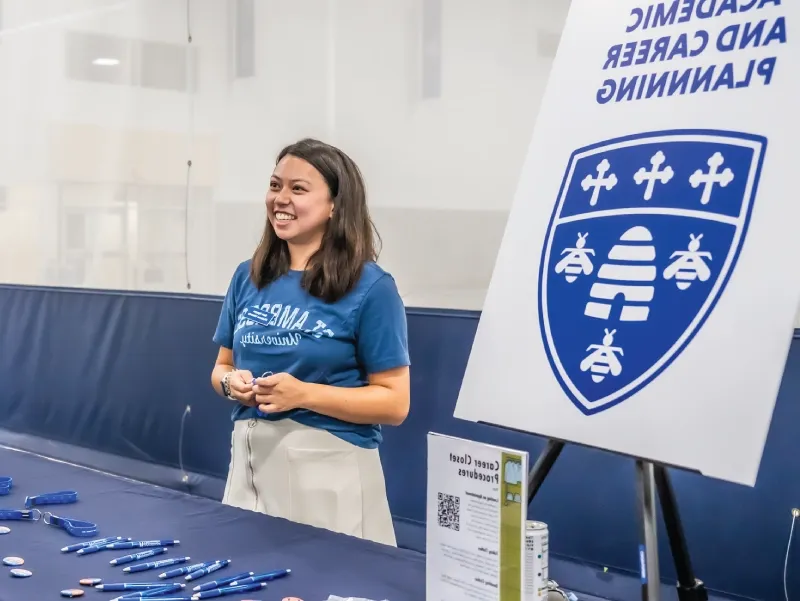 A student standing at a table with a woman at the Career Center.